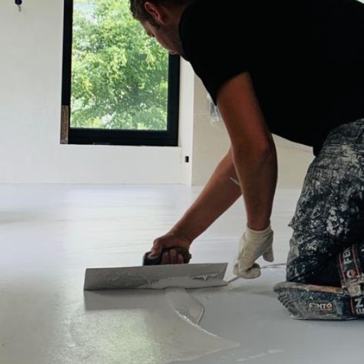 Foto van een medewerker die een gietvloer aanlegt in Nijmegen